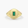 Signet ring featuring a baguette-cut emerald-hued stone and sparkling accents