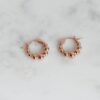 Graduated beaded hoop earrings with a clean, textured finish