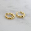 Thick gold-plated beaded hoop earrings with a modern finish