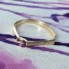 Gold-plated ring featuring a slender bar and sparkling CZ stones