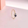 Ring with princess-cut sapphire-hued stone and sparkling accents
