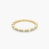 Alternating baguette and round stone eternity ring in polished finish