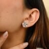 Flower stud earrings featuring aquamarine-inspired CZ stones and prong setting