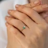 Sterling silver ring featuring a princess-cut emerald and two diamond accents