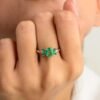 Silver ring featuring emerald accents and subtle diamond sparkle
