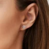 Floral stud earrings featuring thick gold plating and baguette setting