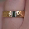Men's wedding band featuring a green sapphire bezel setting
