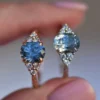 Sterling silver engagement ring with oval light blue sapphire and CZ accents