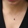 Necklace with oval ruby and round diamond halo setting