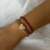 Tennis bracelet with oval CZ ruby stones and gold plating