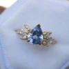 Cluster engagement ring with pastel blue sapphire and diamond stones