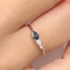 Asymmetrical two-stone ring with pear shape sapphire and CZ diamond