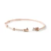 Modern bangle featuring pyramid-inspired edges and studded detail