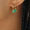 Single huggie earring with pear-shaped emerald drop