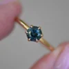 Solitaire engagement ring with a polished silver finish and teal stone