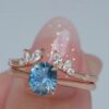 Sterling silver ring set with teal blue sapphire and diamond accents