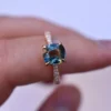 Teal sapphire-inspired engagement ring with pave-set diamond details