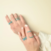 Turquoise round stones in bezel settings on a band ring