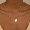 Diamond-framed disc pendant adds a distinctive focal detail
