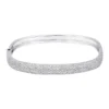 Large pave diamond bangle with a wide, polished silhouette