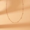 Delicate necklace with bezel-set stones spaced along the chain