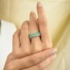 Eternity band ring with baguette emerald accents and round diamond details