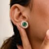 Halo stud earrings highlighting a 6.5 mm Premium CZ emerald centre