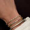 Polished sterling silver bracelet with continuous rainbow sapphire hearts