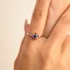 Floral ring design with a blue stone and ruby accents